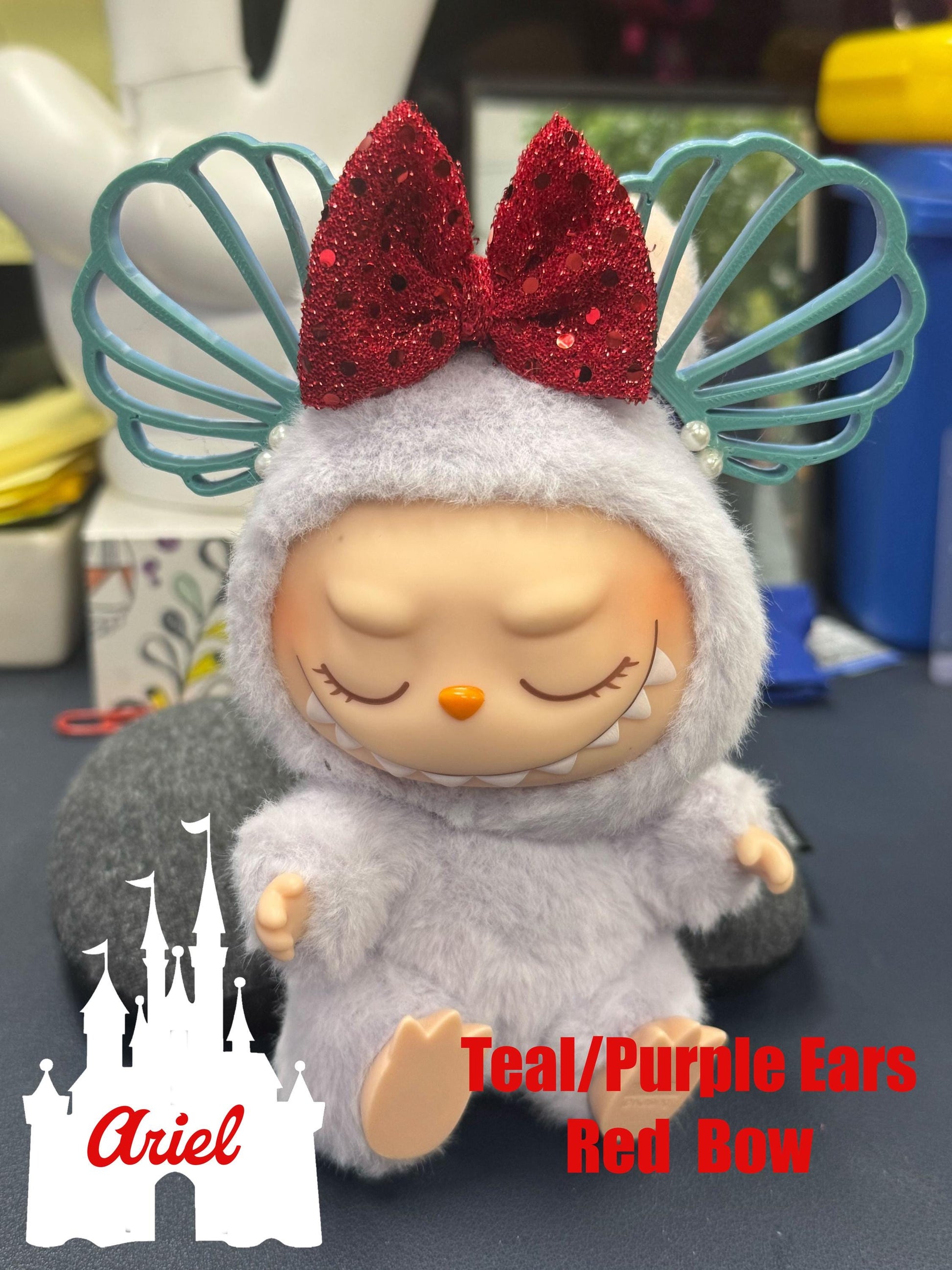 Ariel-inspired Labubu mouse plush with teal and purple ears, red glitter bow, perfect for Disney fans and collectors.