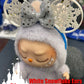 Elsa-inspired Labubu doll with white snowflake ears and a glittery silver bow, perfect for winter-themed accessories.