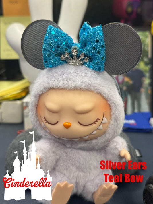 Cinderella-themed Labubu collectible doll with silver mouse ears and teal sparkly bow, perfect for fans and kawaii collectors.
